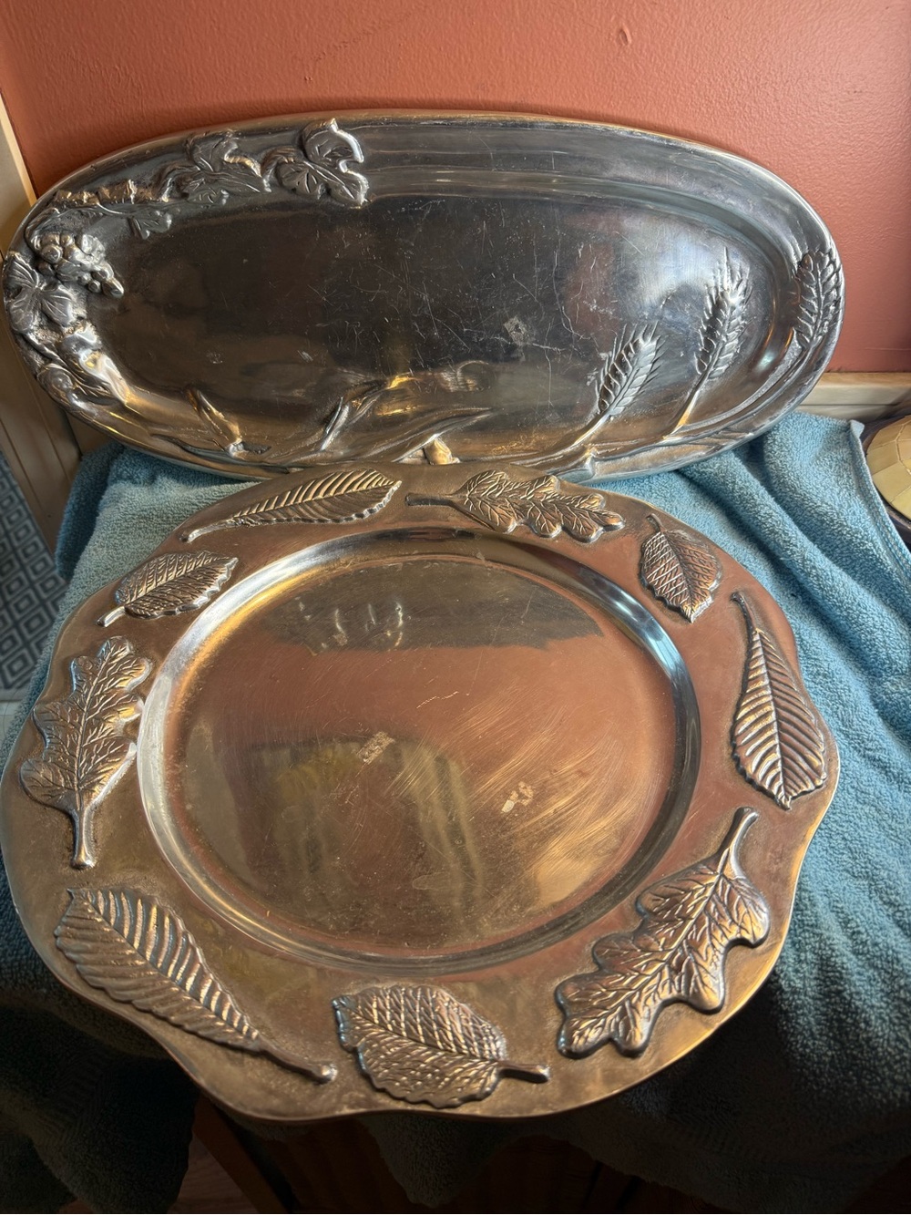 One Mariposa aluminum round platter, one unknown brand silver oval platter